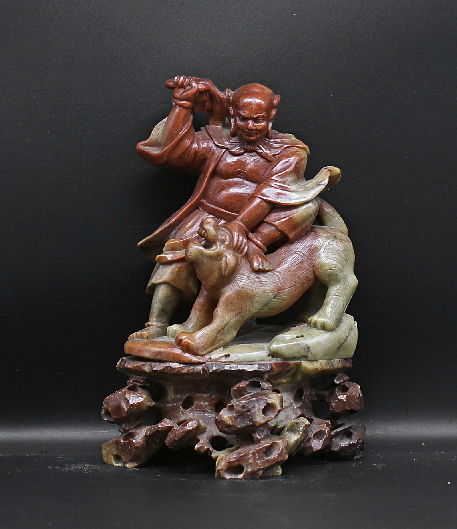 China 1950 Soapstone Luohan statue with a Foo dog 1,15Kg-19 cm: China. 1950 circa. Soapstone Luohan statue with a Foo dog. Finely handmade encarved with hardstone pedestal attached. Green and red color. Rare extremely fine. 1,15 Kg. - 19x13x10 cm