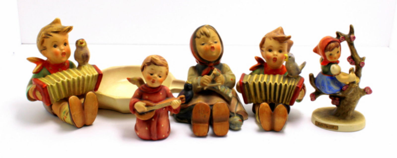 Five Goebel Hummel Figurines: Five Goebel Hummel figurines includes ashtraylet's sing, happy pastime, apple tree, girl angel serenade and let's sing measures 3 3/4" High. Angel has small chip, sold as is.