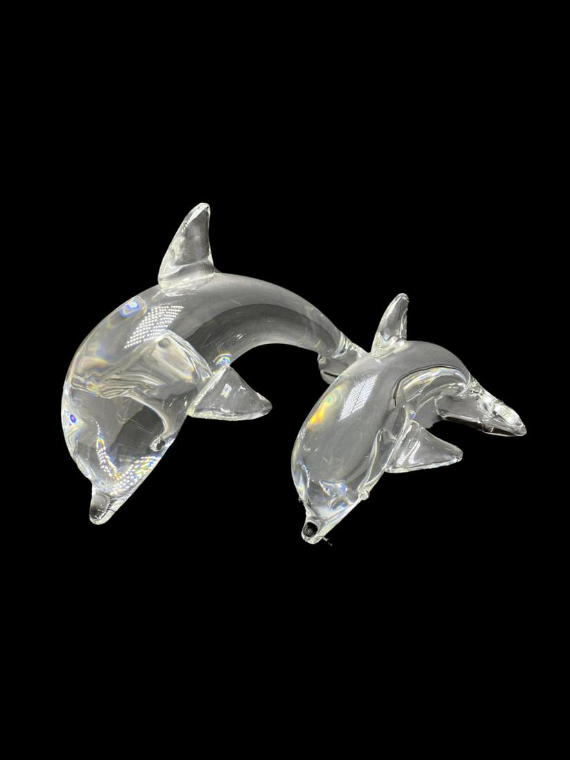Two Pcs Signed Steuben Glass Dolphin Figurines: Two Pcs Signed Steuben Glass Dolphin Figurines signed Steuben on bottom. Larger piece measures Height: 5 3/4" x Length: 9" and the other measures Height: 4" x Length: 7"