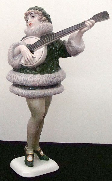 ROSENTHAL PORCELAIN FIGURE PLAYING A BANJO: Rosenthal Porcelain Figure of a Young Woman playing a banjo. She is wearing a green coat with fur 12" Height. SHIPPING & REQUIRED INSURANCE $15.00 WITHIN THE CONTINENTAL U.S., FOR INTERNATIONAL SHIPPI