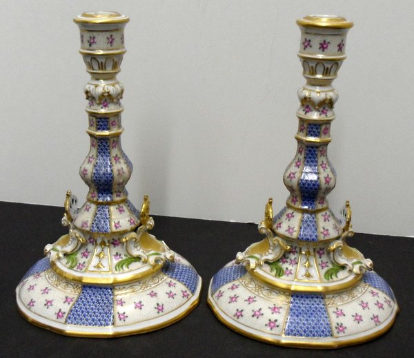 PAIR AUGUST REX PORCELAIN CANDLESTICKS: Pair August Rex Porcelain Candlesticks, hand painted flowers & gold trimming with two small crowns on bases, blue and gold decorations throughout, surface scratches & minor loss to guilt 9 1/4" height