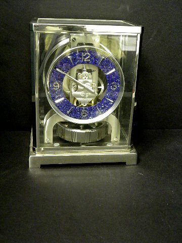 Lecoultre Atmos Clock: An unusual silvered Jeager Le Coultre Atmos Clock. Having a front opening case, and round Lapiz Lazuli designed dial. Caliber 526-5. Serial # 410714. Not guaranteed to be working. Measures approximate