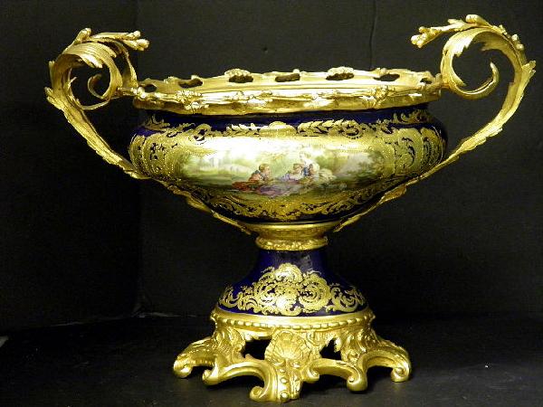 Sevres Chateau Des Tuileries Centerpiece: A museum quality sevres Chateau Des Tuileries Dore Bronze mounted center piece. The front decorated with a large gilt framed,hand painted scene of a courting couple and chaperone, signed Lebelle, agai