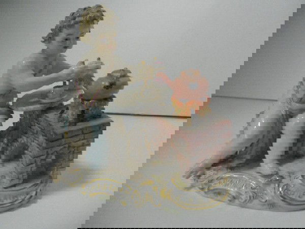 Signed Meissen figure: 19C Meissen figure modelled as a young boy sitting in front of a hearth brewing up a cup of tea. This model is a factory second with the check mark running through the factory blue crossed sword . Min