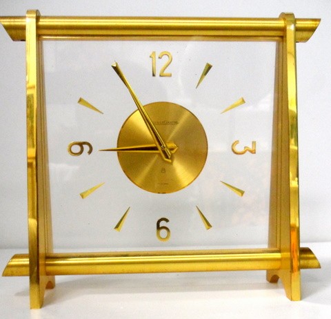 Jaeger Le Coultre Desk Clock: Guilt metal cased 1950's style Jaeger Le Coultre desk clock. The Hands, Batons, and Numerals mounted within clear Perspex. The dial signed Jaeger Le Coultre 8 Swiss made. Mechanical wind movement. App