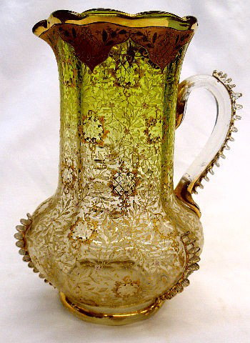 Moser Glass Hand Decorated Pitcher: Moser hand decorated pitcher accented with gilt flowers and leaves. this Vase Has a rasied step decoration on all three sides of pitcher. Glass handle also has the step design accented with gilt trimm