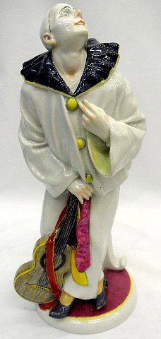 Rudolstadt German Porcelain Clown Figure: Rudolstadt Volkstedt Thuringia Germany Porcelain Figure of a Clown holding a banjo with right hand while looking up. Clown is wearing a white outfit with yellow buttons and blue collar. Base is accent