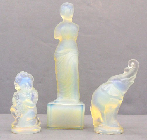 Three Rare Sabino Figurines: Collection of three Sabino figurines in magnificent opalescent crystal. Threse rare vintage figurines feature a statuesque woman, an elephant with raised tusk and small cherub. Very collectable. They 