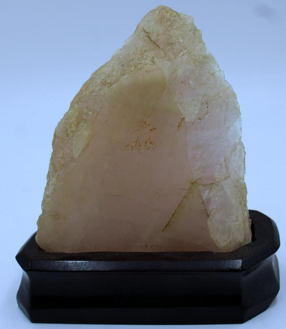 Carved Rose Quartz Stone Specimen On Wooden Stand: A free-form carved rose quartz stone specimen set on fitted wooden display base. Measures approx. 6" height.