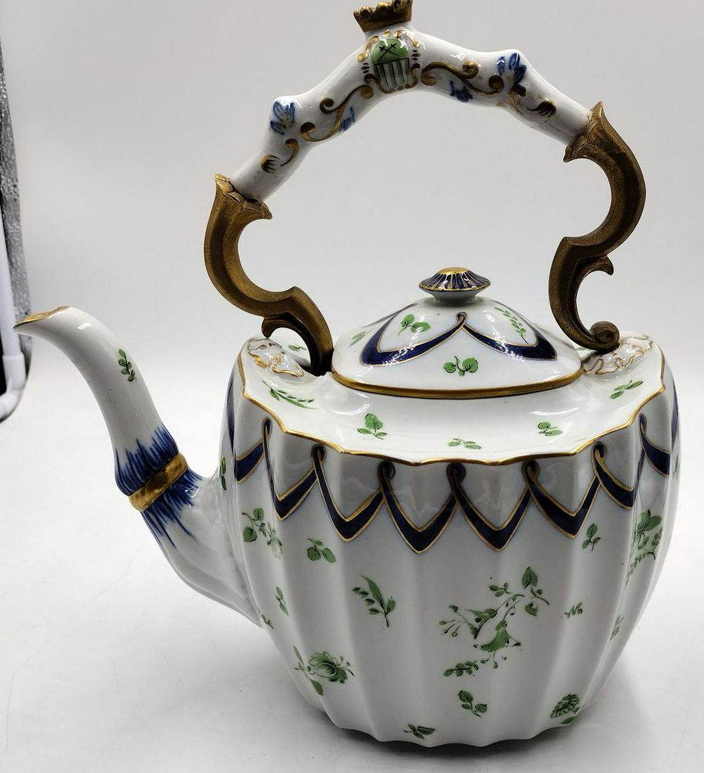 Antique English Porcealin Hand Painted Heraldic Teapot: Antique English hand painted porcelain teapot having a ribbed design to body with cobalt lace patterns and green floral sprays. Hand has gilt metal mounted design with Heraldic crest with crown and cr