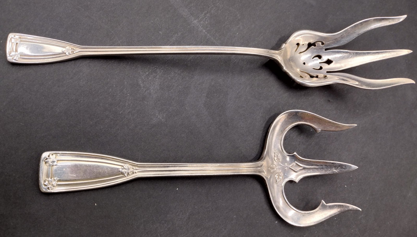 2 Tiffany & Company Sterling Silver "St. Dunstan" Flatware Serving Items: Tiffany And Company American sterling silver flatware serving items in the "St. Dunstan" pattern. Lot is to include a solid bread serving fork (6 5/8") and a macaroni serving fork (8 1/2"). Fully hall