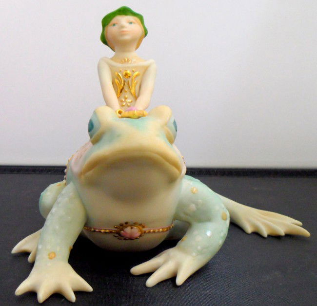 Cybis Woodland Elf on Frog: Retired Cybis porcelain elf on a frog entitled Tiffin, Land of Chimetic. This beautiful porcelain is primarily pastel colored with gold gilt design on both the elf and the frog. Signed Cybis on bottom