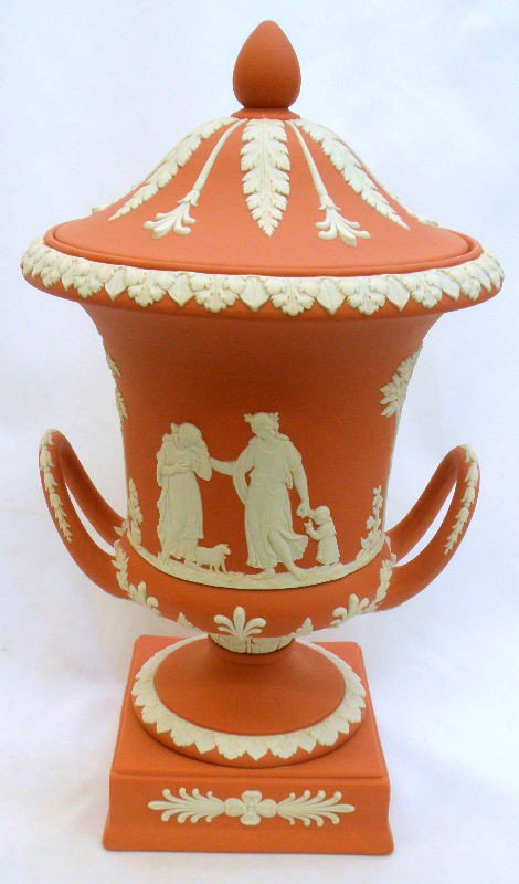 Wedgwood Jasperware Covered Urn: Stunning Jasperware cream colored with classical scenes of courtiers adorn this wedgwood salmon colored covered urn. This urn is in excellent condition and is marked wedgwood. Made in England. Measure