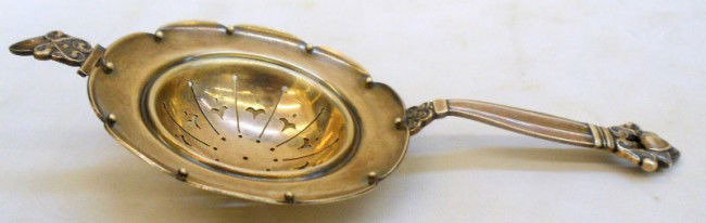 Georg Jensen Acorn Sterling Silver Tea Strainer: Georg Jensen sterling silver tea strainer in the Acorn Pattern. This is the type of teastrainer that goes over the cup. The back of the handle is marked; Denmark Sterling, .925 along with the Georg Je