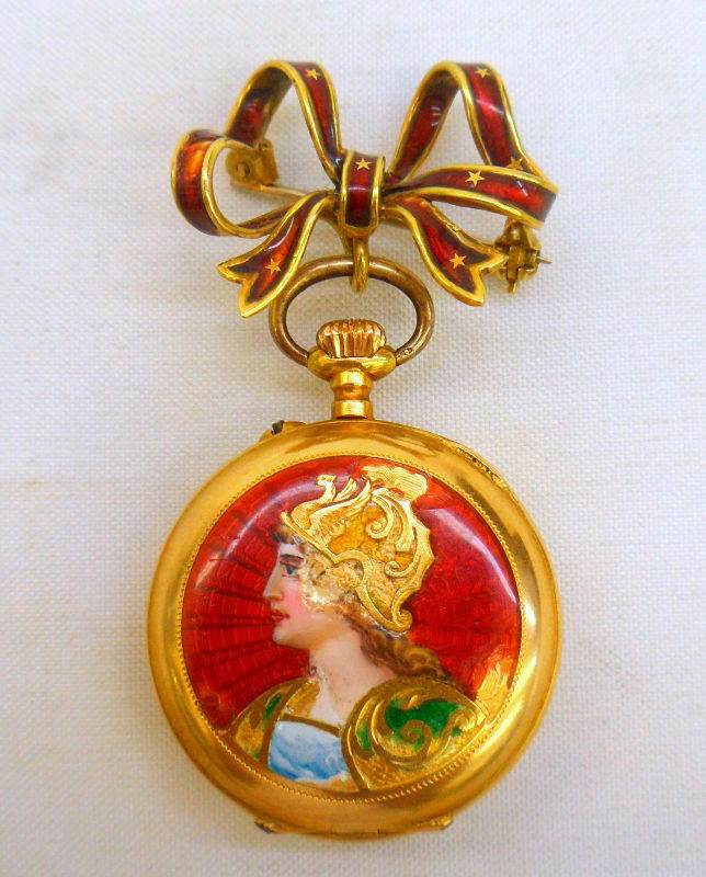 1900s 14K Y.G. Enamel Pendant Watch: Circa 1900s 14K Enamel Pendant Watch. This watch features a enamel bow pin with open face & black roman numerals. Watch has white porcelain dial with white & gold tone. Back of case has red enamel wit