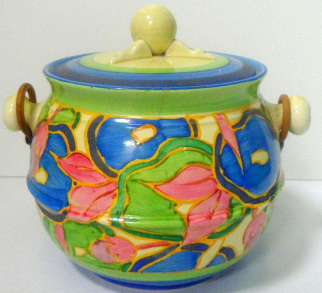 Clarice Cliff Bizarre "Blue Chintz" Biscuit Barrel: Bizarre "Blue Chintz" Bulbous Biscuit Barrel and cover with rattan handle, c. 1932. Clarice Cliff signature on bottom. Measurements with handle 8 1/4" x 7" x 6". Shipping within the continental US is