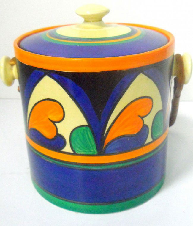 Fantastic Clarice Cliff Bizarre Biscuit Barrel: Fantastic Clarice Cliff Bizarre Biscuit Barrel with bold blue orange, blue and turquoise cover and rattan handle. This Bizarre Barrel with handle measures 8 1/2" x 6 1/2" x 5 1/2". Shipping within the