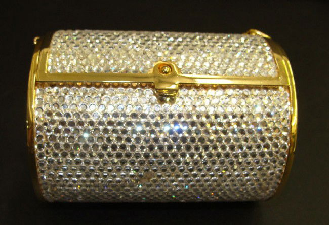 Judith Leiber Swarovski Crystal Purse: Beautiful Judith Leiber purse decorated with Swarovski crystals all around. Gilt trimming on borders and chain. Measures, purse - 2 1/4" high x 3 1/4" wide x 2 1/4" depth, chain - 24 1/2" long. Very g