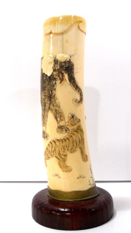 Chinese Polychrome Ivory Tusk: Important chinese ivory tusk of an elephant and a tiger carved in high relief with fine detail. The piece sits in a custom-made bronze and wood base. Measures 10 1/4" high x 4 1/4" wide. Shipping with