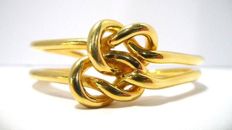 18K Y.G. Love Knot Bangle Bracelet: Very fine 1970's Cartier "Love Knot" bangle bracelet featuring a open frame designed 18K yellow gold mounting weighing 26.80dwt - 41.81g. Shipping within the continental US is $20 plus Required insura