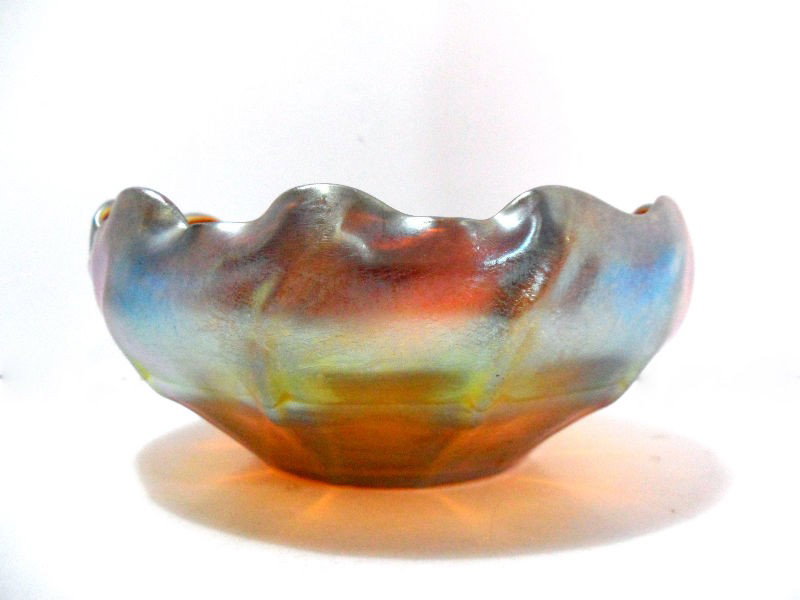 Tiffany L.C.T. Favrile Signed Bowl: A Tiffany L.C.T. Favrile bowl circa. 1900. The bowl is a burnished gold color that emits hues of blue and green. The bottom contains the etched signature "L.C.T. Favrile", which represents Louis Comfo