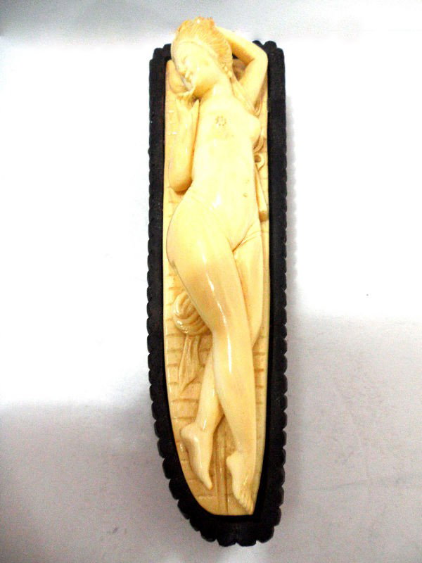 Chinese Carved Ivory Doctor's Lady: Beautiful Chinese Carved ivory doctor's lady reclining on a carved wooden base. One hand is rested behind the figure's head while the other is by her chin. A carved fan is located by her side. Measure