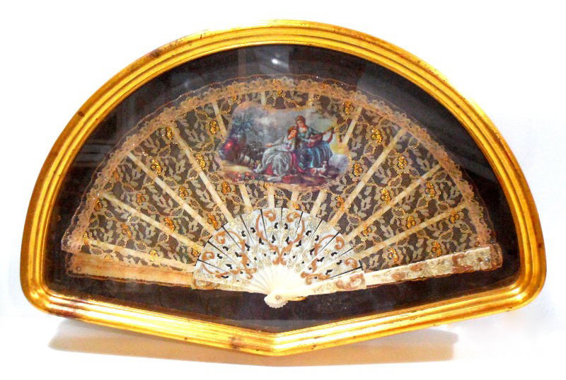 Italian Ivory Fan in a Frame: Beautiful Italian ivory fan in a gilt wood frame. The fan is decorated with gilded lace and a painted applique depicting a pastoral scene. 13"X 20 1/2". Shipping within the continental US is $40 plus 