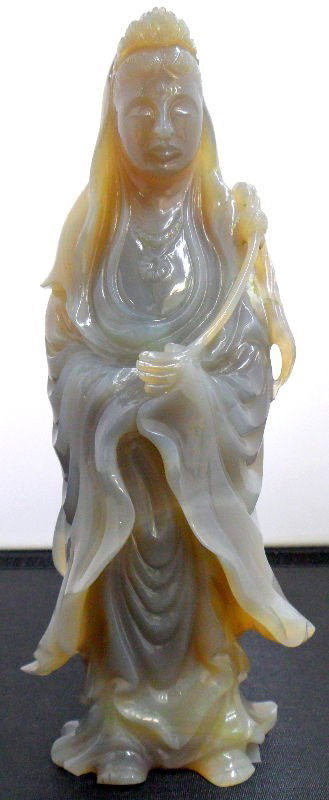 Chinese Agate Quan Yin Figurine: Chinese carved agate figure of a Quan Yin. This beautifully carved figure appears to be holding a scepter and is dressed in a long flowing robe and adorned with jewels and headress. The piece itself h