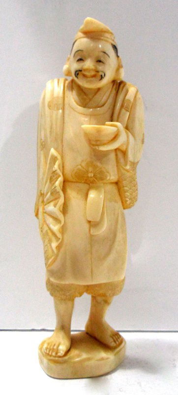 Chinese Ivory Figure of a Man: A Chinese ivory figure of a man. He is wearing a cap and dressed in simple robes decorated with flowers. In one hand he holds a small bowl and in the other an open fan. 5 1/4"H. Shipping within the co