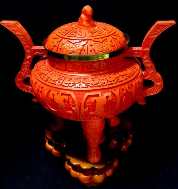 Chinese Cinnabar and Gilt Metal Censer: Highly impressive Chinese cinnabar and gilt metal mounted censer. The lid is carved topped with a foo dog. Elaborate geometric carvings decorate the bowl, handles, and tripod feet. The whole piece res