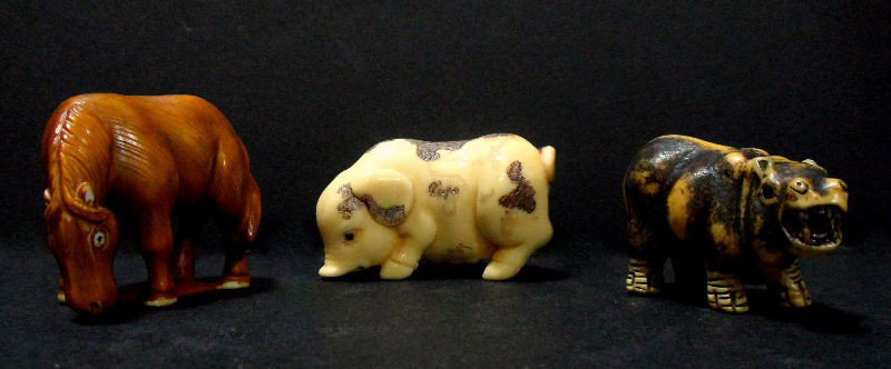 Chinese Ivory Animal Netsukes (3): Three Chinese ivory Nestukes. One of a pig, a horse, and a hippo. The pig is a light cream colored ivory with black pen work spots; the horse is tinted a caramel color, and the hippo is cream colored 