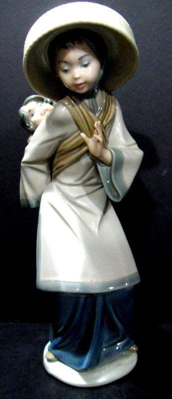 Lladro Porcelain Figure "My Precious Bundle": Lladro porcelain figure "My Precious Bundle." No. 5123 , Issued 1982 Retired 1998. 10 1/2"H. Current retail: $355.00. The Lladro mark is featured on the bottom. Shipping within the continental US is $