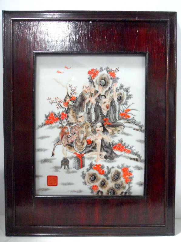 Chinese Antique Painted Porcelain Panel: An antique Chinese painted porcelain panel in a wood frame. The panel depicts a scene with three robed men sitting in nature with a stag. It is primarily red and black in color on a white porcelain ba