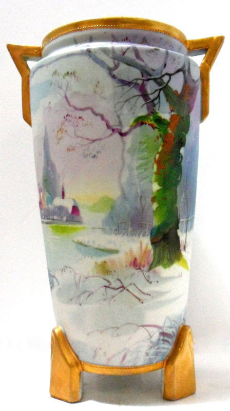 Nippon Hand Painted Vase: Nippon hand painted vase with gold painted handles and base. This porcelain piece has a beautifully painted landscape with strong lavender based colors. The porcelain attached feet and handles are a b