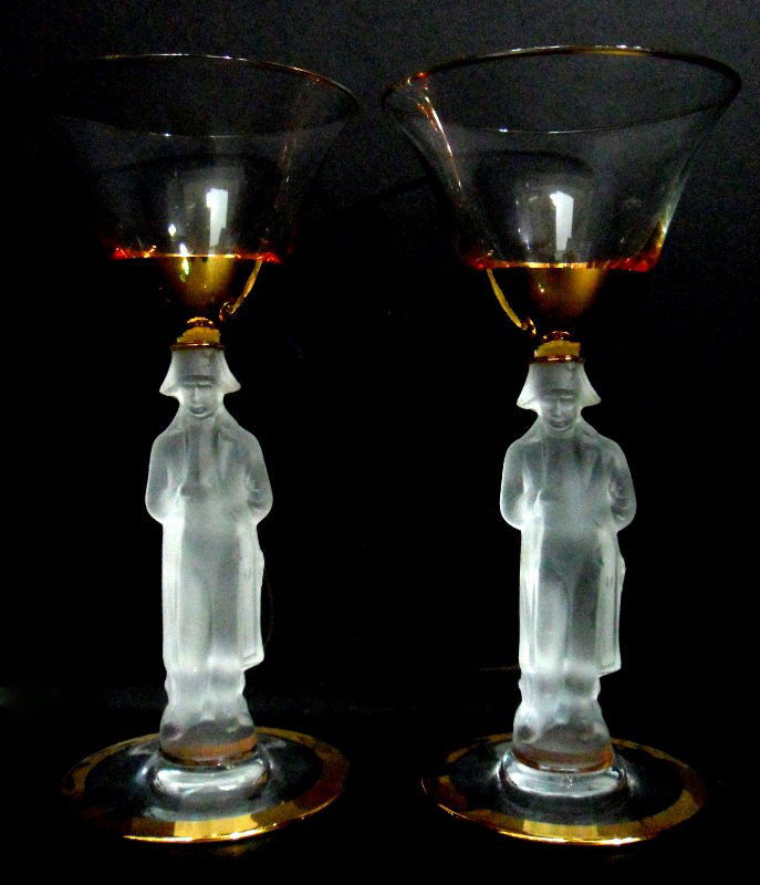 Gold Rimmed Red Wine Glasses with Napoleon (16): Set of 16 red wine glasses with a gold rim and a stem molded in the shape of Napoleon Bonaparte. Each glass features Napoleon in his signature pose, with one hand tucked into his jacket, as the stem-p