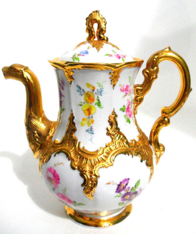 Meissen Porcelain and Gilt Coffee Pot: Meissen porcelain and gilt coffee pot. The coffee pot is beautifully hand painted with color flowers. The handle, rim, base, and central scroll work are all done in gilding. The spout is shaped like a