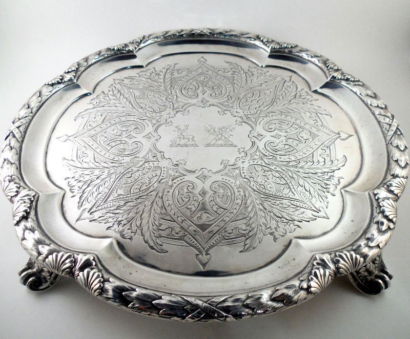 Robert Hennell III Sterling Silver Salvers (2): Pair of sterling silver salvers by London silversmith Robert Hennell III made in 1862. Each piece features a border of delicately cut leaves. The interiors of the salvers are engraved with elaborate h