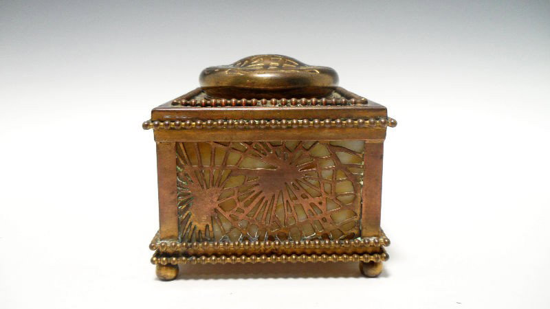 Tiffany Studios Inkwell: Tiffany Studios Inkwell in the pine needle pattern. The pine needle design covers caramel color slag glass. Marked 23 and Tiffany Studios New York on bottom. 3" height x 3 7/8" diameter. SHIPPING & RE