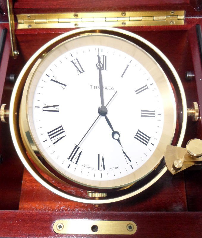 Tiffany & Co. Swiss Made Nautical Clock: Tiffany & Co. Swiss made nautical clock. With quartz resonator. Adjustable brass platform. Handsome mahogany case. Swiss made. Case measures 7" X 7" X 7". Shipping within the continental US is $75 plu