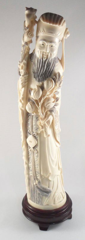 Chinese Ivory Scholar Holding Peach Blossoms: Chinese ivory figure of a scholar holding peach blossoms and a staff with a scroll. Incising filled in with pen work is used to accent the figure's robes and props. Marked on the bottom. Measures 12"H