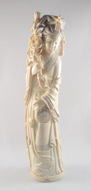 Chinese Ivory Figure of a Floral Beauty with Fan: Chinese Ivory figure of a floral beauty. She is holding a Chrysanthemum branch in one hand and a small fan in the other. Pen work and incising are used as decorations on the figure's flowing robes. Pi