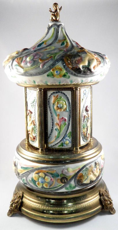 Capodimonte & Reuge Carousel Music Box: Capodimonte and Reuge carousel music box. The piece I activated by pressing a button on the back of the carousel; the panels turn with the music to reveal small compartments. The porcelain is beautifu