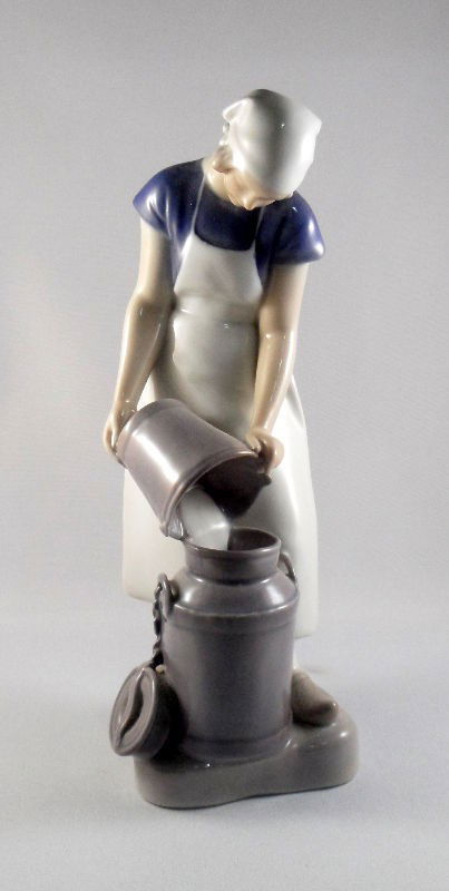 Bing & Grondahl Milkmaid Figurine: Bing & Grondahl milkmaid figurine. A young woman pours milk into a large bucket. Marked with the Bing & Grondahl seal on the bottom. Measures 8 3/4"H. Shipping within the continental US is $30 plus Re