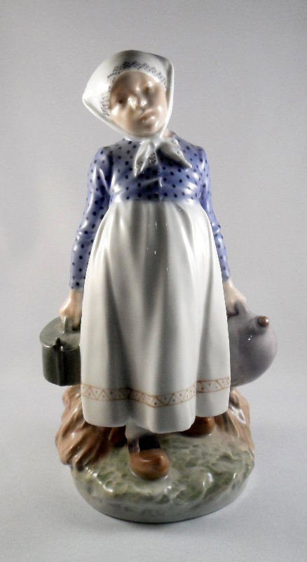Royal Copenhagen Figurine, #815: Royal Copenhagen figurine, #815 entitled "Peasant Girl with Lunch." Marked Royal Copenhagen on the bottom and dated to 1956. Measures 9"H. Shipping within the continental US is $30 plus Required insur