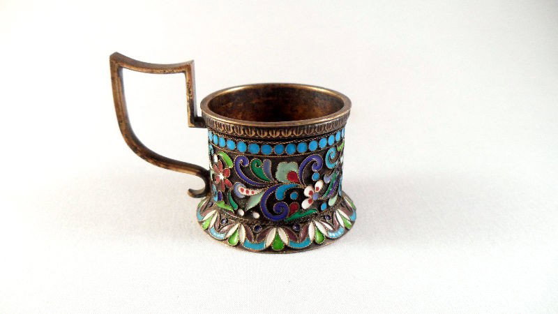 Russian Silver and Enamel Candle Holder: Russian silver and enamel candle holder. The piece is beautifully decorated with colorful floral lacquer designs. A small handle is attached. Bottom is marked with a Cyrillic maker's mark and kokoshni