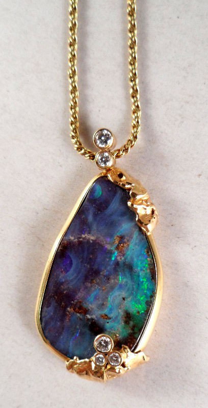 George Jensen 18K Gold & Diamond Pendant: George Jensen beautifully crafted 18K yellow gold and diamond pendant containing a large centralized bolder opal with 18K extension chain. Can be worn as 18"L or 24"L. 5 round diamonds, which equal ap
