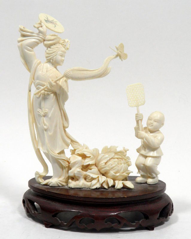 Chinese Republic Ivory Carving Maiden with a Child: Chinese Republic ivory carving of a maiden with a child. The maiden stands tall with flowing robes and holds a fan height in one hand and a ceremonial broom in the other. A butterfly sits on the end o