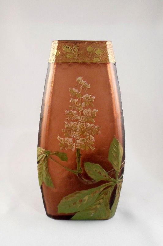 Mont Joye Brown Glass, Gilt, and Enamel Vase: Mont Joye brown glass, gilt and enamel vase. The top of the vase has a gilt border with fruit and leaves. Large green leaves with pink flowers are painted onto the main body of the piece. Marked Mont