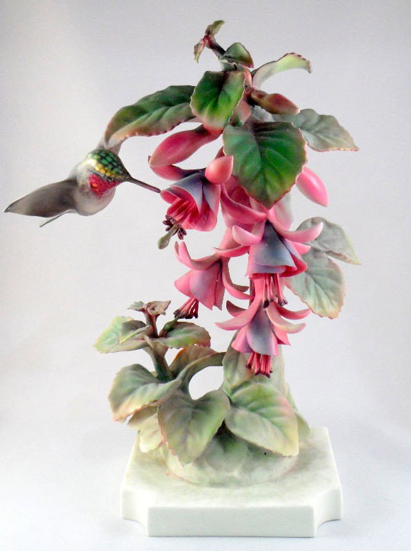 Royal Worcester Porcelain Figurine of a Humming Bi: Royal Worcester porcelain figurine of a humming bird sucking nectar from a floral tree. The bottom is marked "Ruby Throated Humming Bird," and with the Royal Worcester mark. Measures 10"H. For Domesti