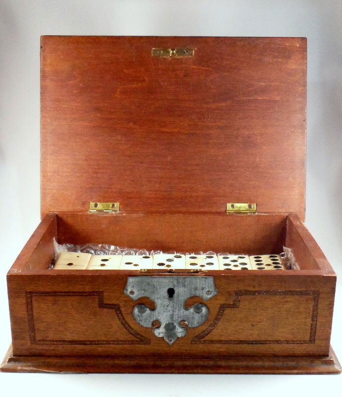 Antique Ivory & Ebony Dominos Set: Antique ivory and ebony domino set. The dominos are crafter so that one side is ivory and the other ebony. Set is contained in a wood and metal overlay box. Box measures 3 1/4" X 5 3/4" X 9".For Domes